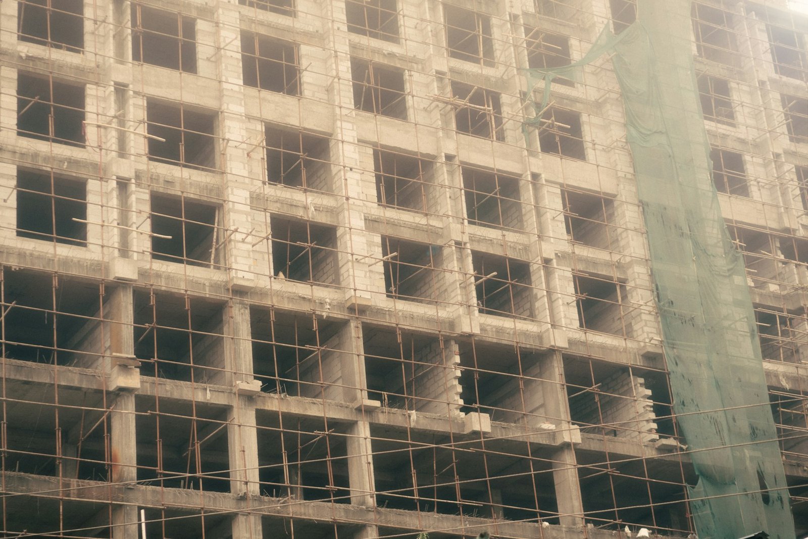Clădire rezidențială în construcție cu schelă montată pe fațadă